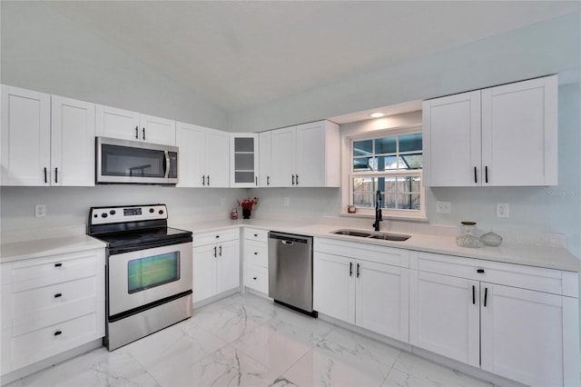 kitchen with white cabinetry, sink, stainless steel appliances, and lofted ceiling