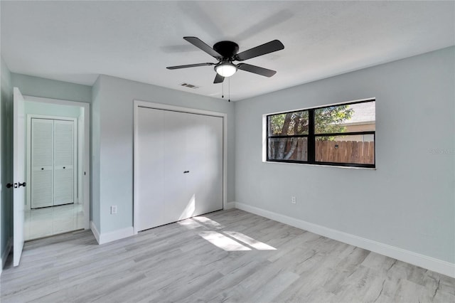 unfurnished bedroom featuring ceiling fan, light hardwood / wood-style floors, and a closet