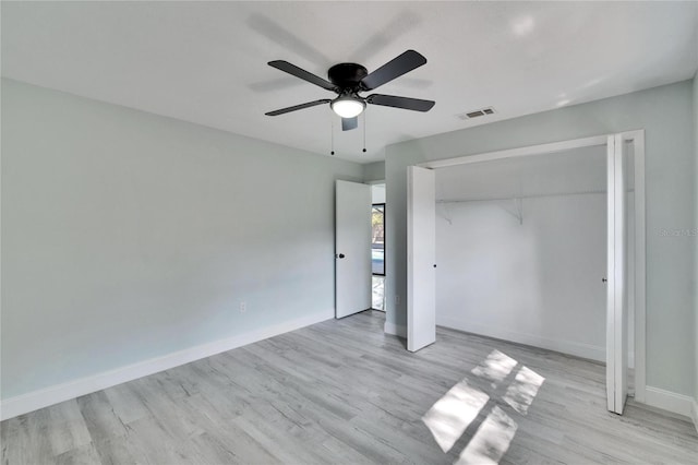 unfurnished bedroom with ceiling fan, light wood-type flooring, and a closet