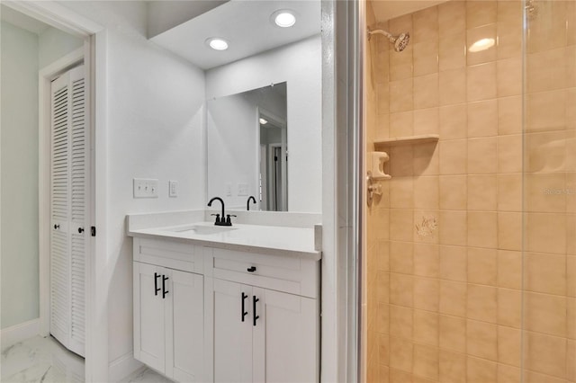 bathroom with vanity and a tile shower