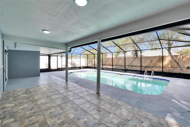 view of swimming pool featuring glass enclosure and a patio area