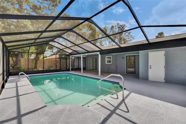 view of swimming pool featuring a patio and glass enclosure