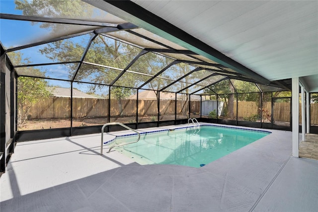 view of swimming pool with a patio, glass enclosure, and a shed