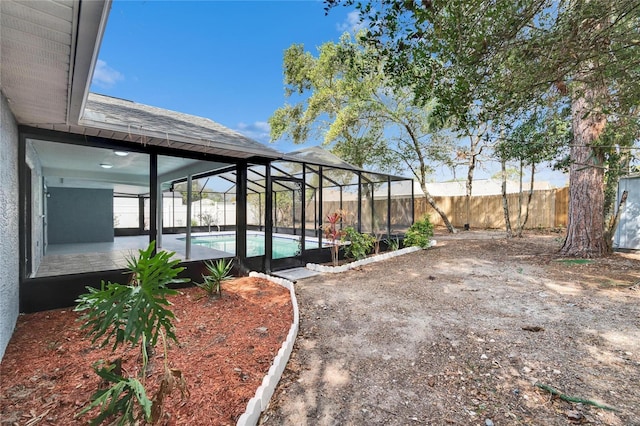 view of yard featuring a fenced in pool, a patio, and glass enclosure