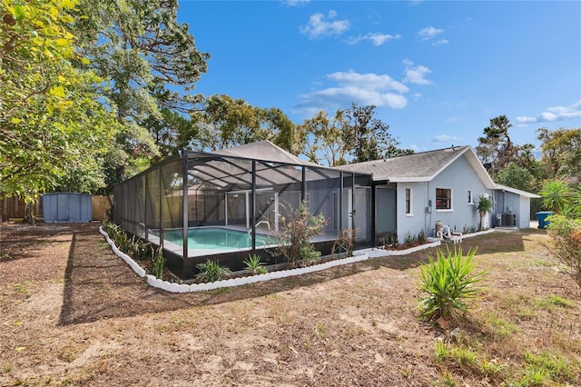 back of property with a storage shed, a lawn, glass enclosure, and central air condition unit