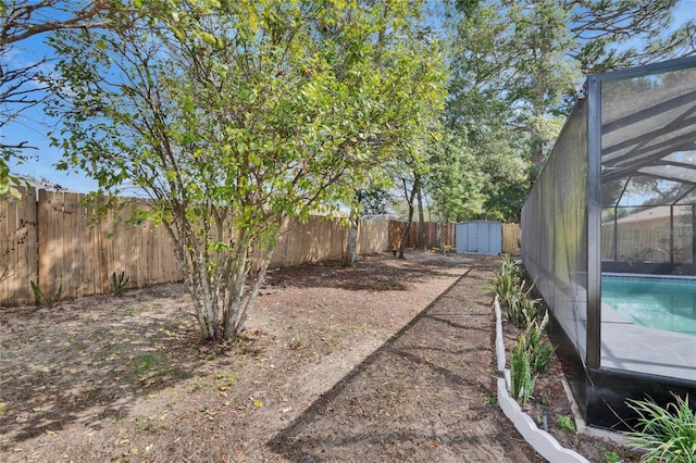 view of yard featuring glass enclosure and a storage unit