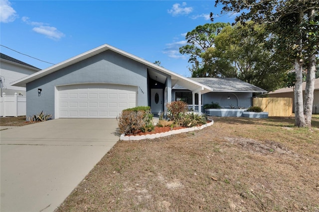 ranch-style home featuring a garage and a front lawn