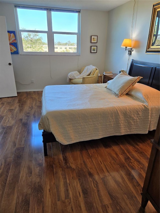 bedroom with dark hardwood / wood-style floors