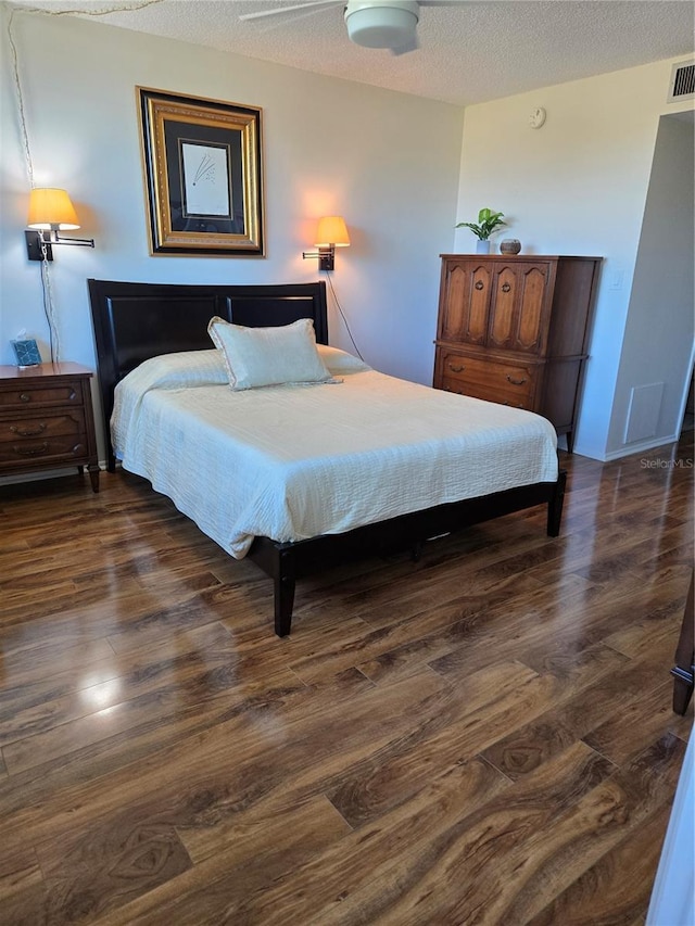 bedroom with dark hardwood / wood-style flooring and a textured ceiling