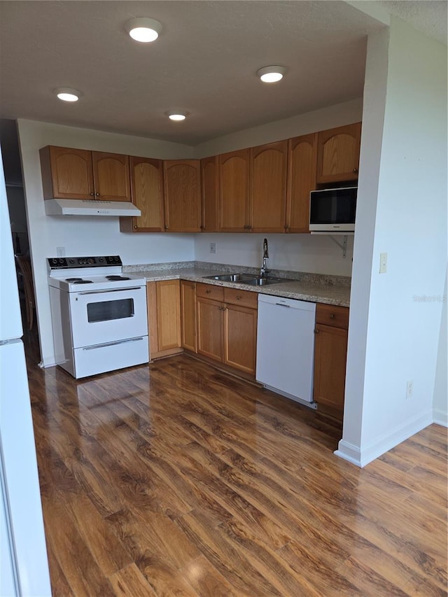 4915 Bay St NE Unit 322, Saint Petersburg, FL 33703 - kitchen with white appliances, a sink, under cabinet range hood, dark wood finished floors, and baseboards