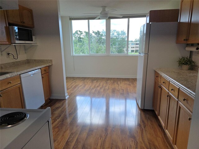 4915 Bay St NE Unit 322, Saint Petersburg, FL 33703 - kitchen with white appliances, a ceiling fan, dark wood-style floors, baseboards, and brown cabinetry