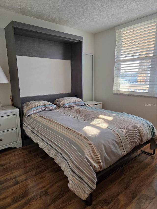 4915 Bay St NE Unit 322, Saint Petersburg, FL 33703 - bedroom featuring a textured ceiling and dark wood-type flooring