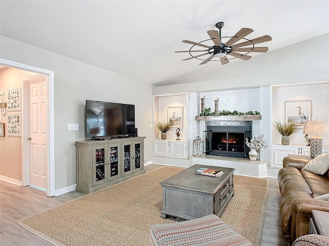 living room with hardwood / wood-style flooring, vaulted ceiling, and ceiling fan