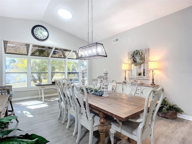 dining area with lofted ceiling and light hardwood / wood-style floors