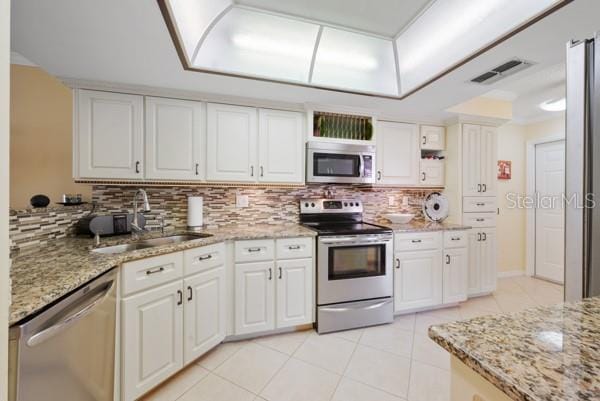 kitchen featuring stainless steel appliances, sink, and white cabinets