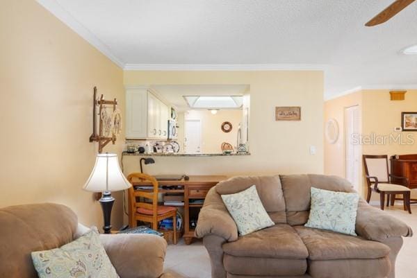 carpeted living room featuring ornamental molding and ceiling fan