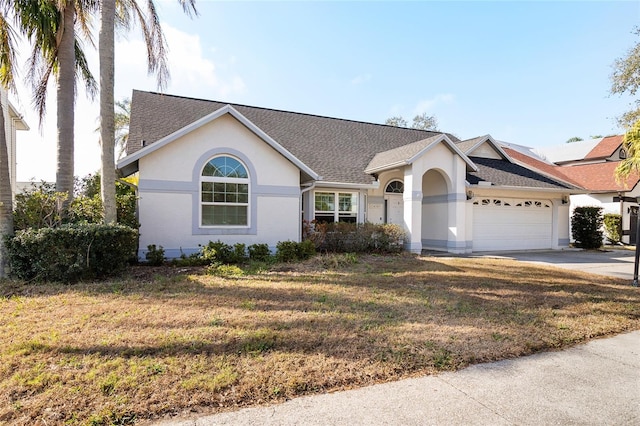 ranch-style home with a garage and a front yard