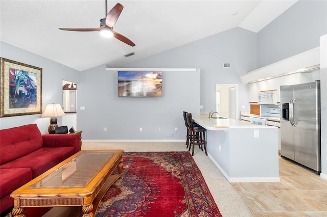 living room with high vaulted ceiling, sink, light carpet, and ceiling fan