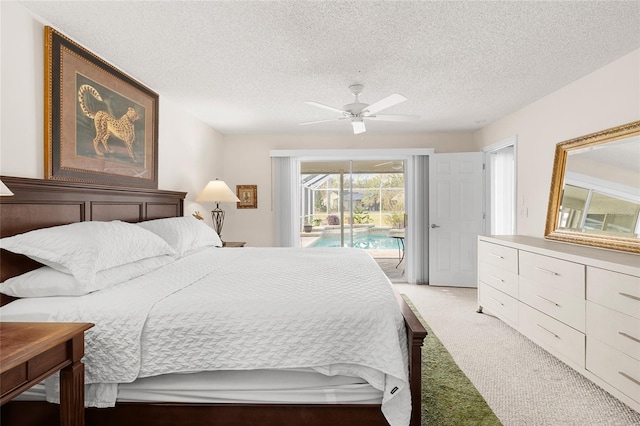 carpeted bedroom featuring ceiling fan, access to exterior, and a textured ceiling