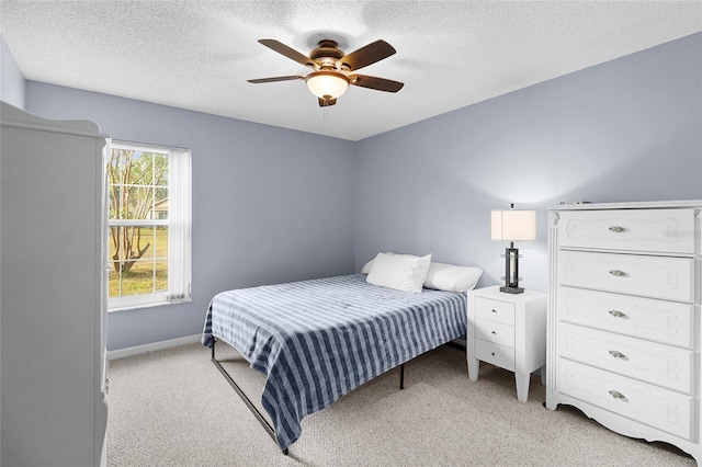 carpeted bedroom featuring ceiling fan and a textured ceiling