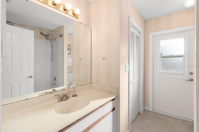 full bathroom with tiled shower / bath combo, vanity, a textured ceiling, and toilet