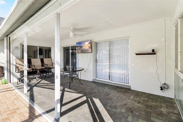 unfurnished sunroom with ceiling fan