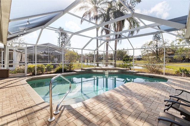 view of pool with a patio, glass enclosure, and a water view