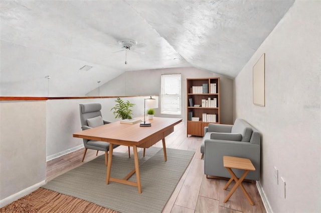 office area featuring ceiling fan, lofted ceiling, and light wood-type flooring