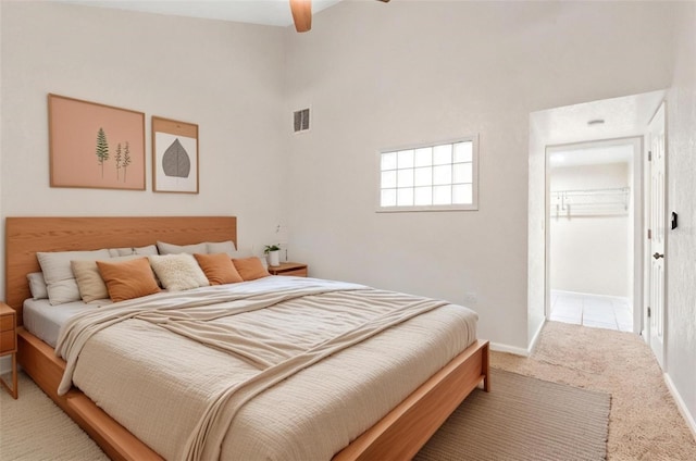 bedroom featuring carpet, a towering ceiling, and ceiling fan