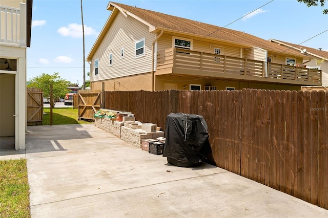 view of property exterior with a patio and a balcony