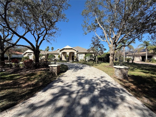 view of front of property with a front yard and decorative driveway