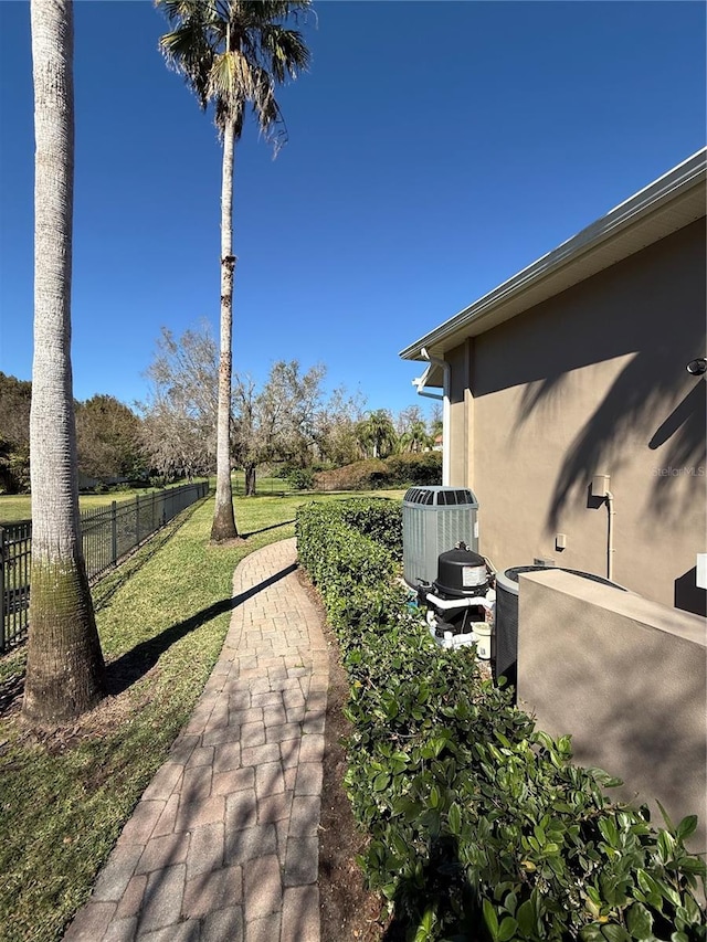 view of yard featuring central AC, a patio area, and fence