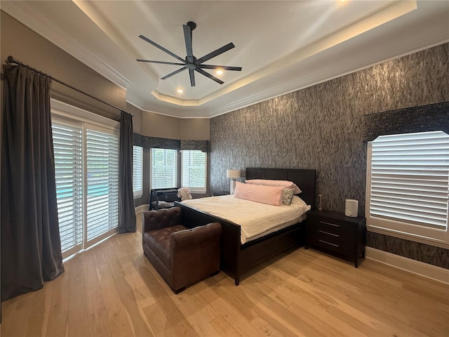 bedroom featuring ceiling fan, light wood-type flooring, a raised ceiling, and baseboards