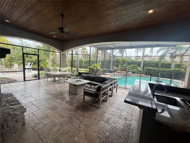 sunroom / solarium featuring wooden ceiling, a sink, a ceiling fan, and a healthy amount of sunlight