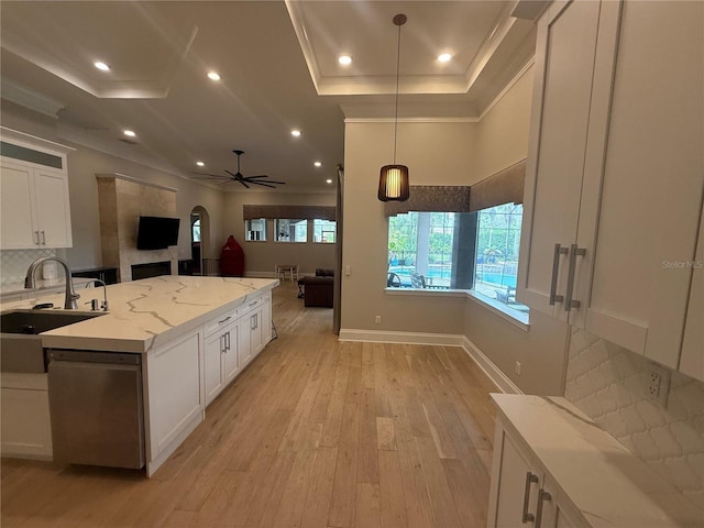 kitchen featuring white cabinets, light stone counters, pendant lighting, and open floor plan