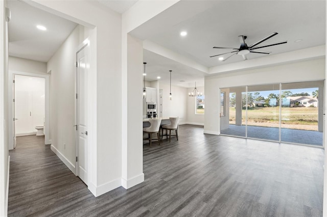 hall with dark wood-type flooring and an inviting chandelier