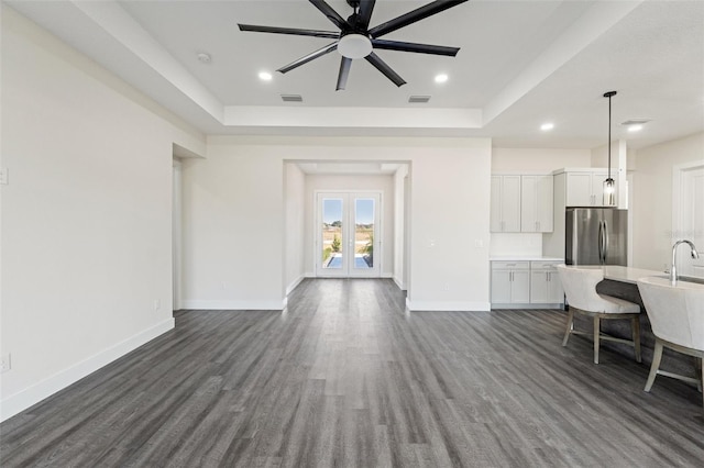 living room featuring french doors, dark hardwood / wood-style floors, and a raised ceiling