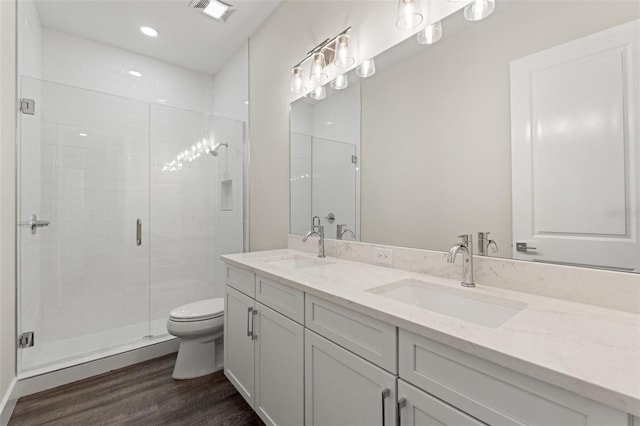 bathroom with vanity, toilet, an enclosed shower, and hardwood / wood-style floors