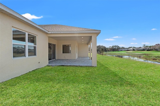 view of yard with a patio area and a water view