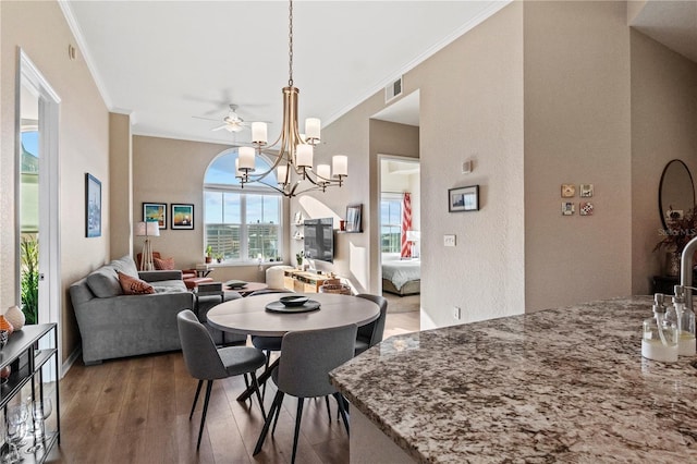 dining area featuring hardwood / wood-style floors, crown molding, and ceiling fan with notable chandelier