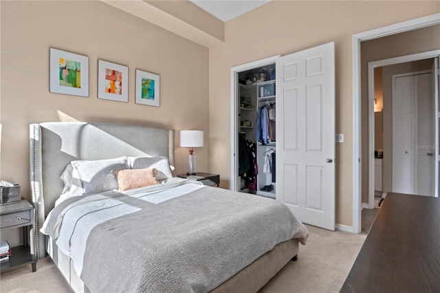 bedroom with a spacious closet, light colored carpet, and a closet