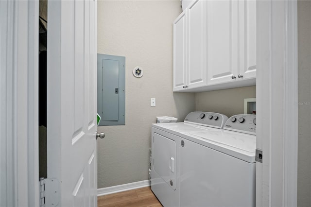 laundry area featuring cabinets, independent washer and dryer, electric panel, and light wood-type flooring