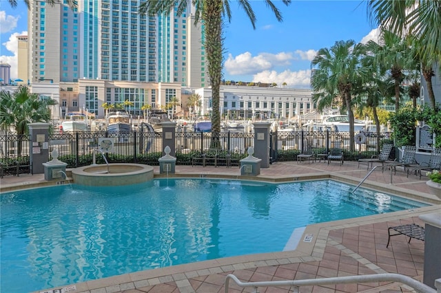 view of pool featuring pool water feature, a patio area, and a community hot tub