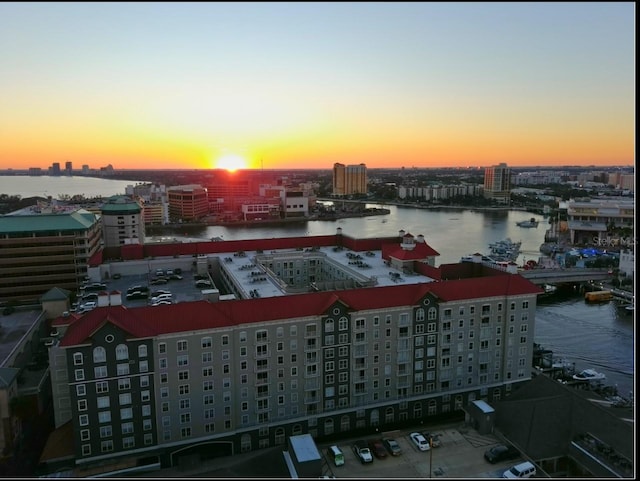 aerial view at dusk featuring a water view