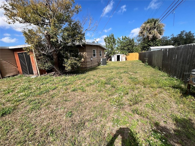 view of yard with central AC unit and a storage unit