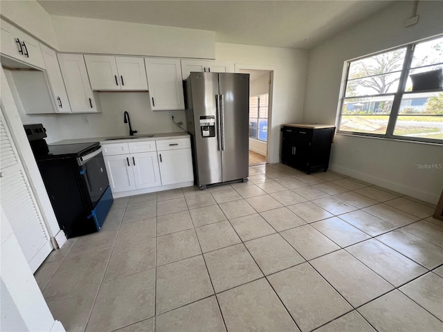 7563 Meadowlawn Dr N, Saint Petersburg, FL 33702 - kitchen with black electric range oven, stainless steel fridge, sink, and white cabinets