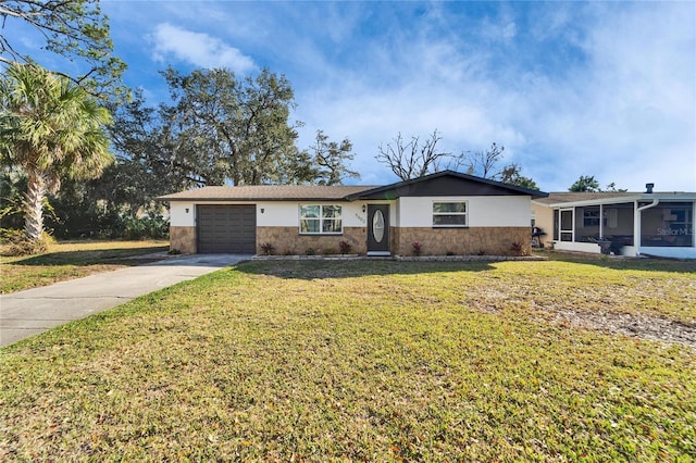 single story home with a garage, a sunroom, and a front yard