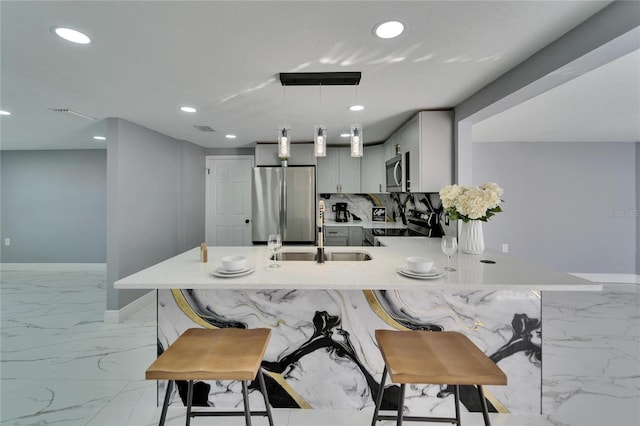 kitchen featuring sink, decorative light fixtures, gray cabinets, kitchen peninsula, and stainless steel appliances