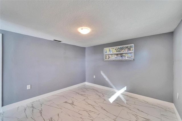 unfurnished room with a textured ceiling