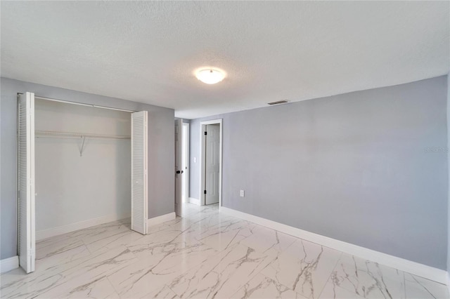 unfurnished bedroom with a closet and a textured ceiling